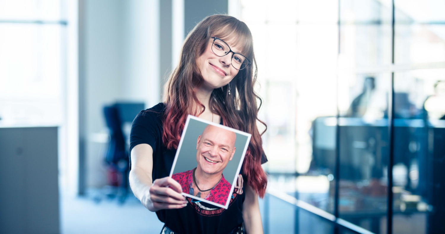 Eine Schülerin hält ein Foto ihres Lehrers in der Hand.