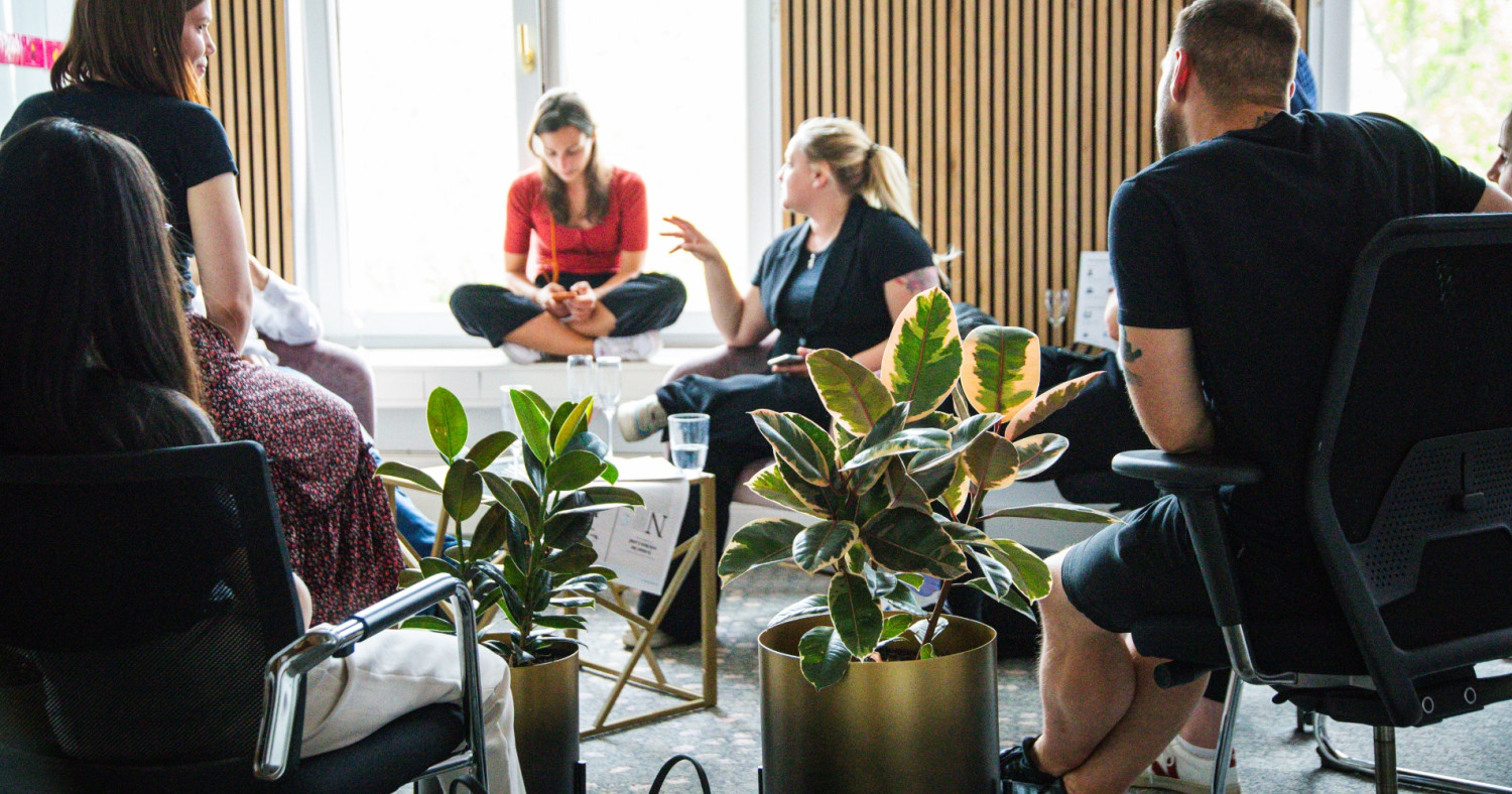 Fünf Menschen aus dem PIO-Team sitzen im Leipziger Büro und tauschen sich aus.