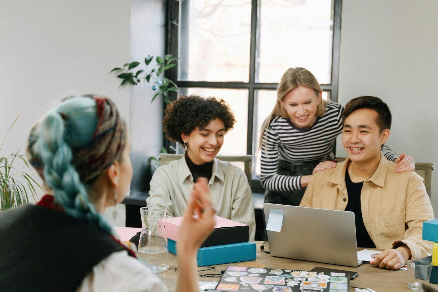 Vier junge Menschen arbeiten gemeinsam in einem hellen Büro.