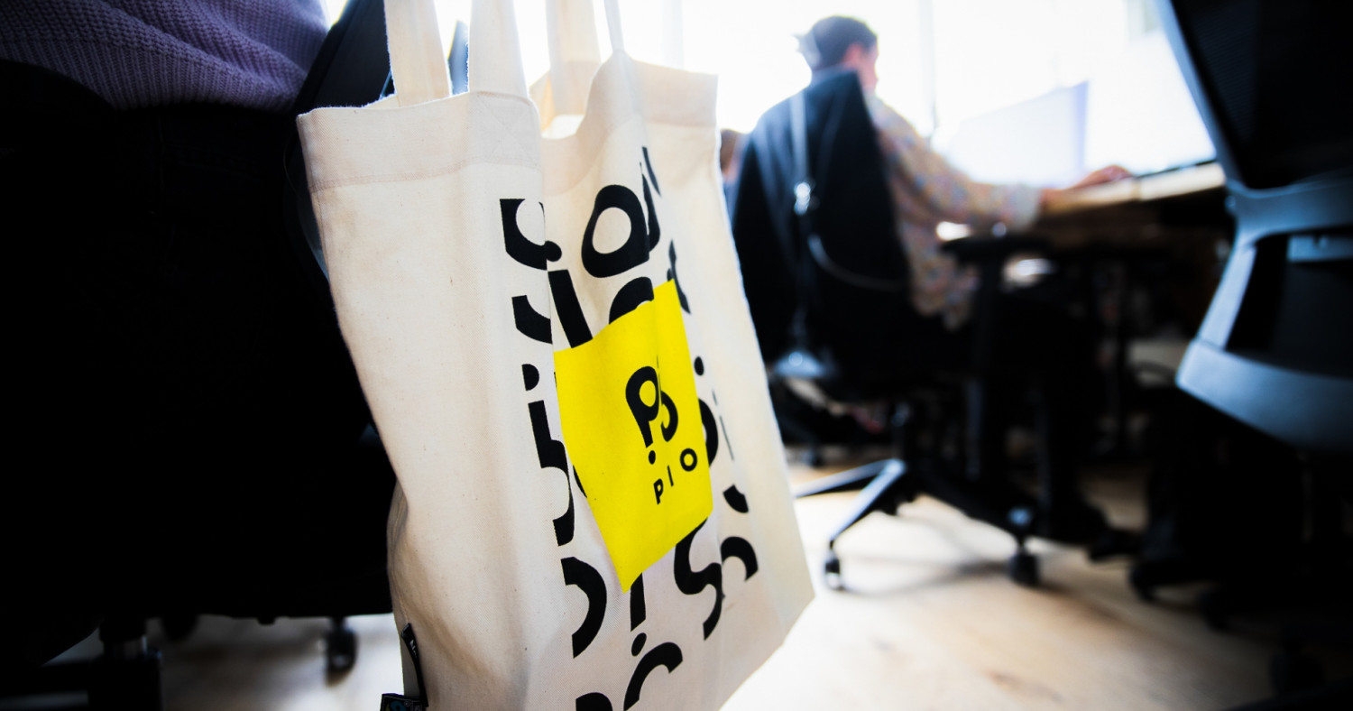 Ein Stoffbeutel mit dem neuen PIO-Logo hängt an einem Stuhl im Leipziger Büro.