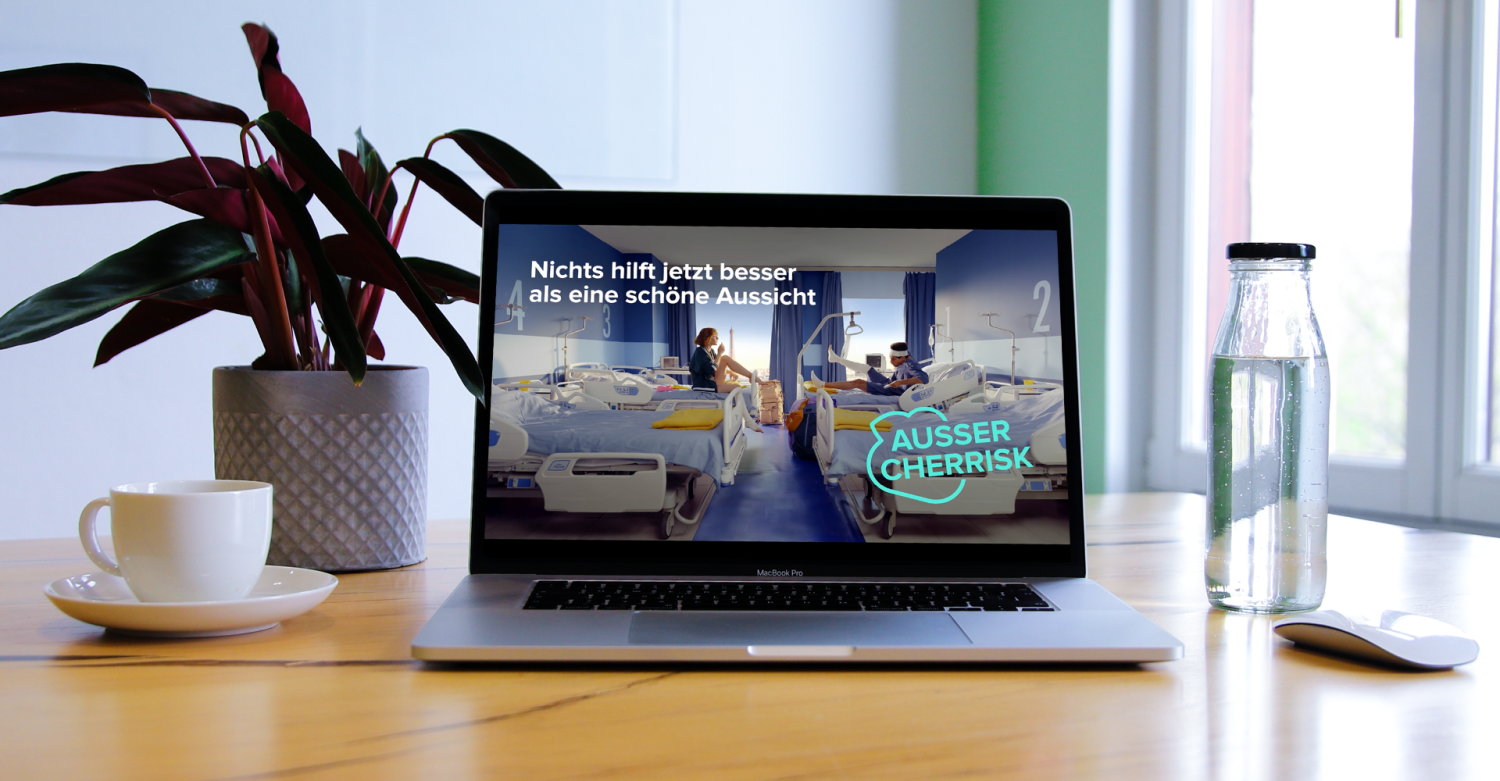 Laptop auf dem CHERRISK Werbung zu sehen ist, mit einer Kaffetasse, einer Grünpflanze und einer Wasserkaraffe daneben