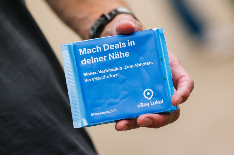 Eine Person hält eine Tafel Schokolade von eBay in der Hand.