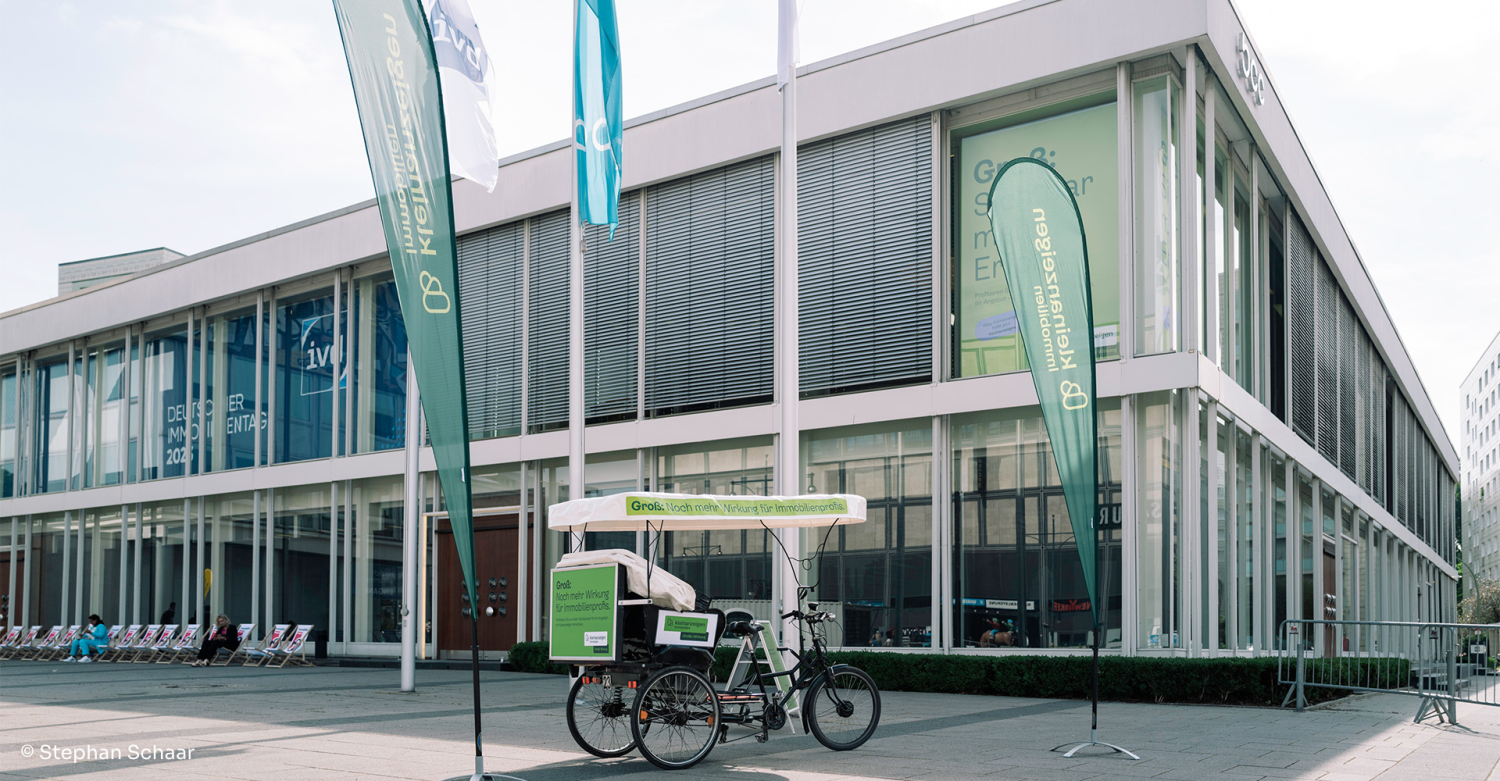 Eine Rikscha und mehrere Fahnen im Kleinanzeigen Immobilien-Design vor der Messehalle