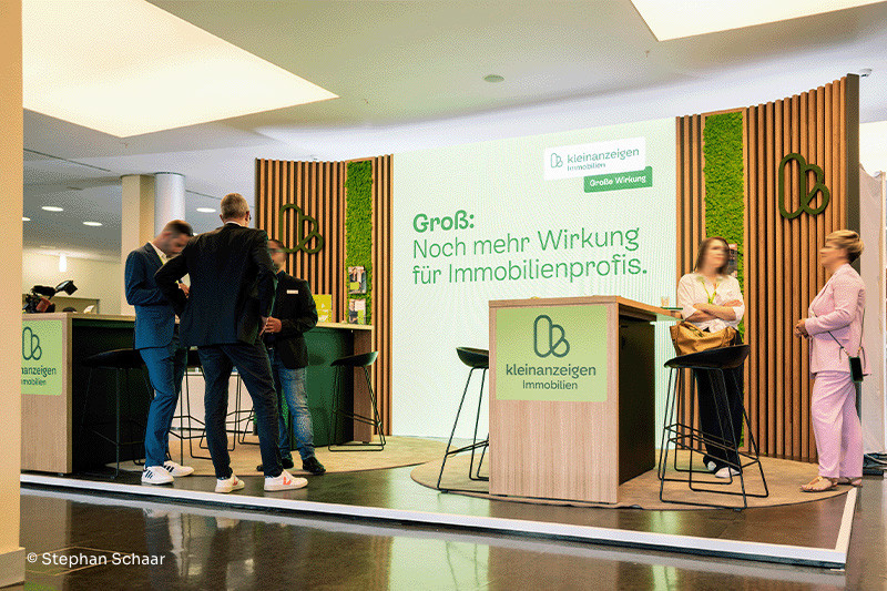 Der Messestand von Kleinanzeigen Immobilien in Holzoptik und mit vielen grünen Elementen