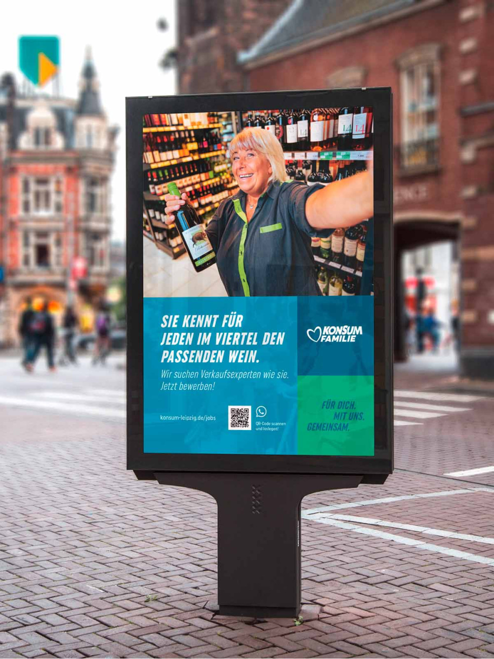 Citylight-Poster in einer Einkaufsstraße mit Kampagnenplakat von Konsum
