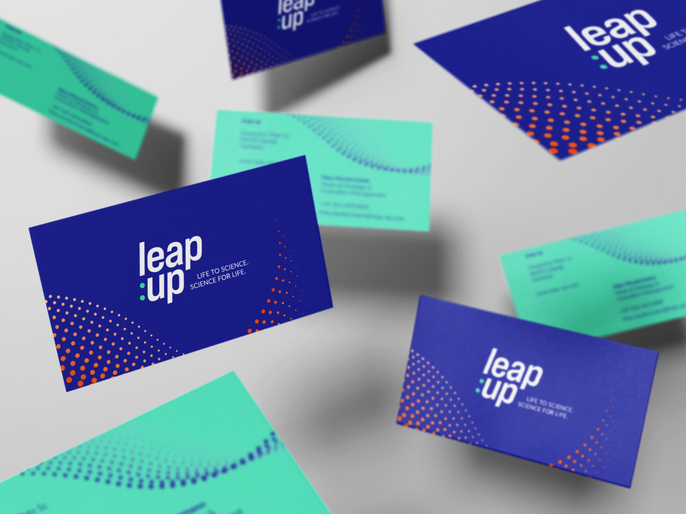 Some blue-green leap:up business cards fly through the picture