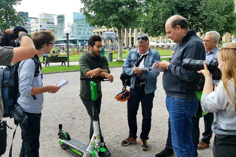Members of the media interviewing a Lime employee