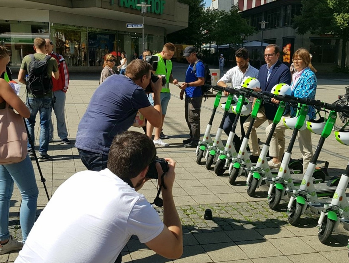 Pressevertreter*innen, die Lime-Scooter fotografieren