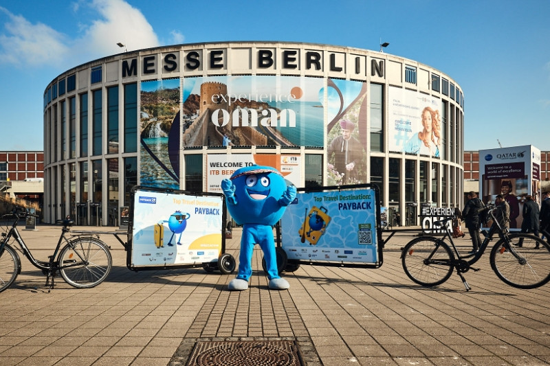 Ein Pointie, das runde, blaue Maskottchen von PayPack, steht vor der Messe Berlin.