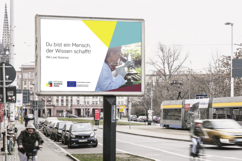 Ein großes Plakat an einer Straße mit dem Schriftzug "Du bist ein Mensch, der Wissen schafft!"