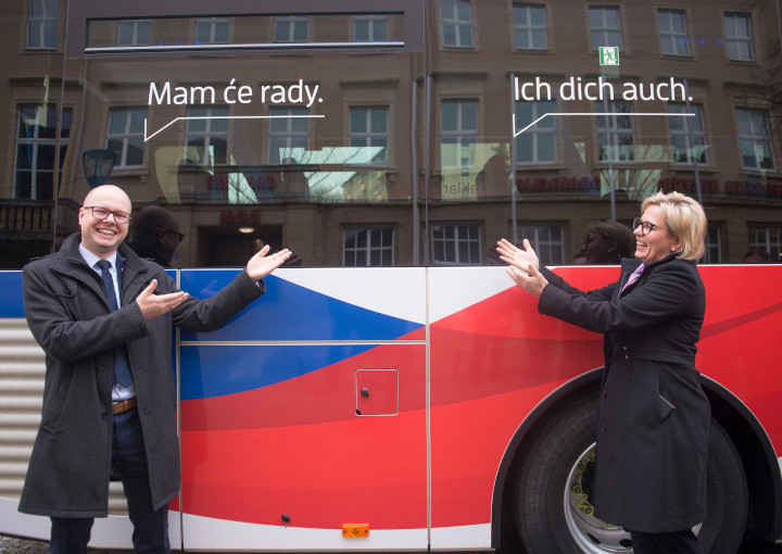 Buswerbung von "Sorbisch? Na klar!" mit zwei Personen, die vor dem Bus stehen und diese präsentieren